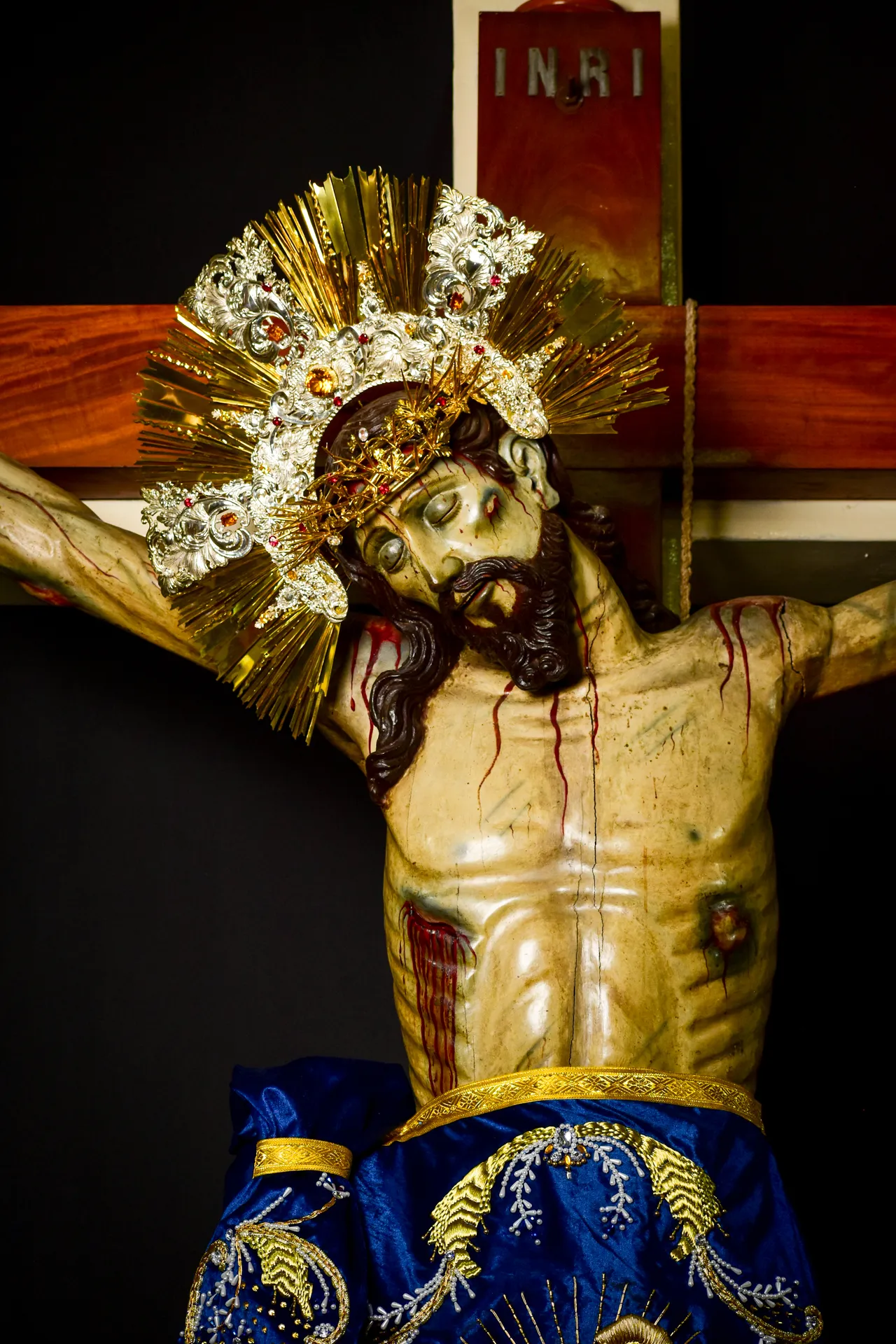 Busto del Divino Salvador del Mundo con su resplandor de oro y plata, bajo el letrero INRI