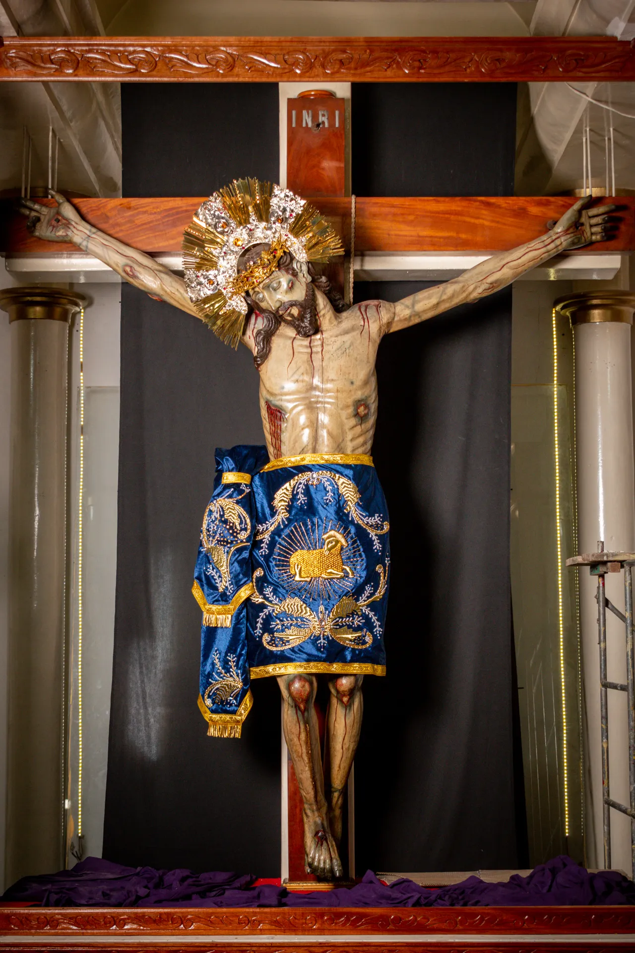 El Divino Salvador del Mundo en su altar, con el paño azul bordado en oro, entre dos columnas y sobre un paño morado