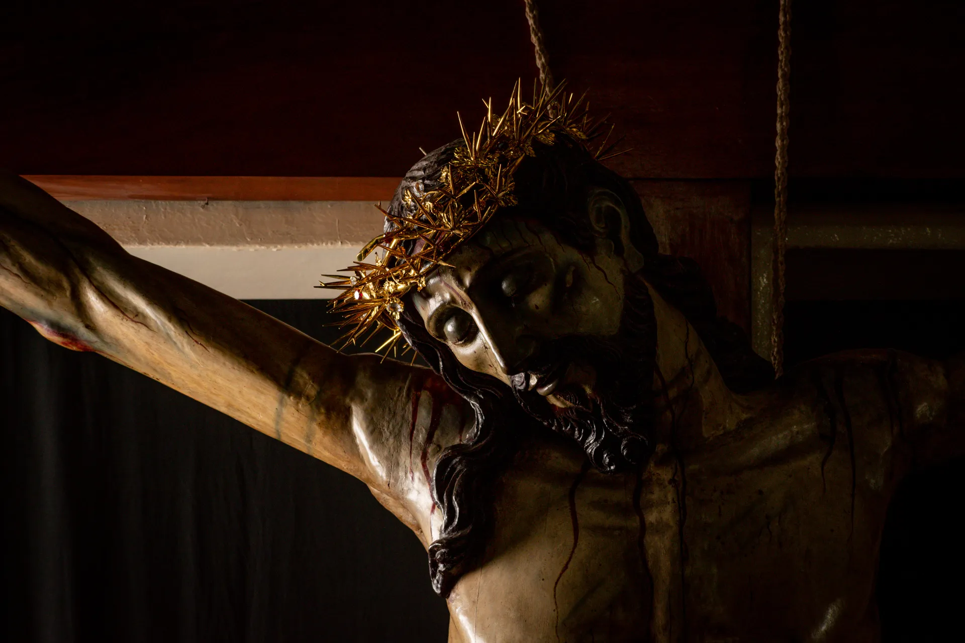 El rostro del Divino Salvador del Mundo en claroscuro, con la corona de espinas dorada
