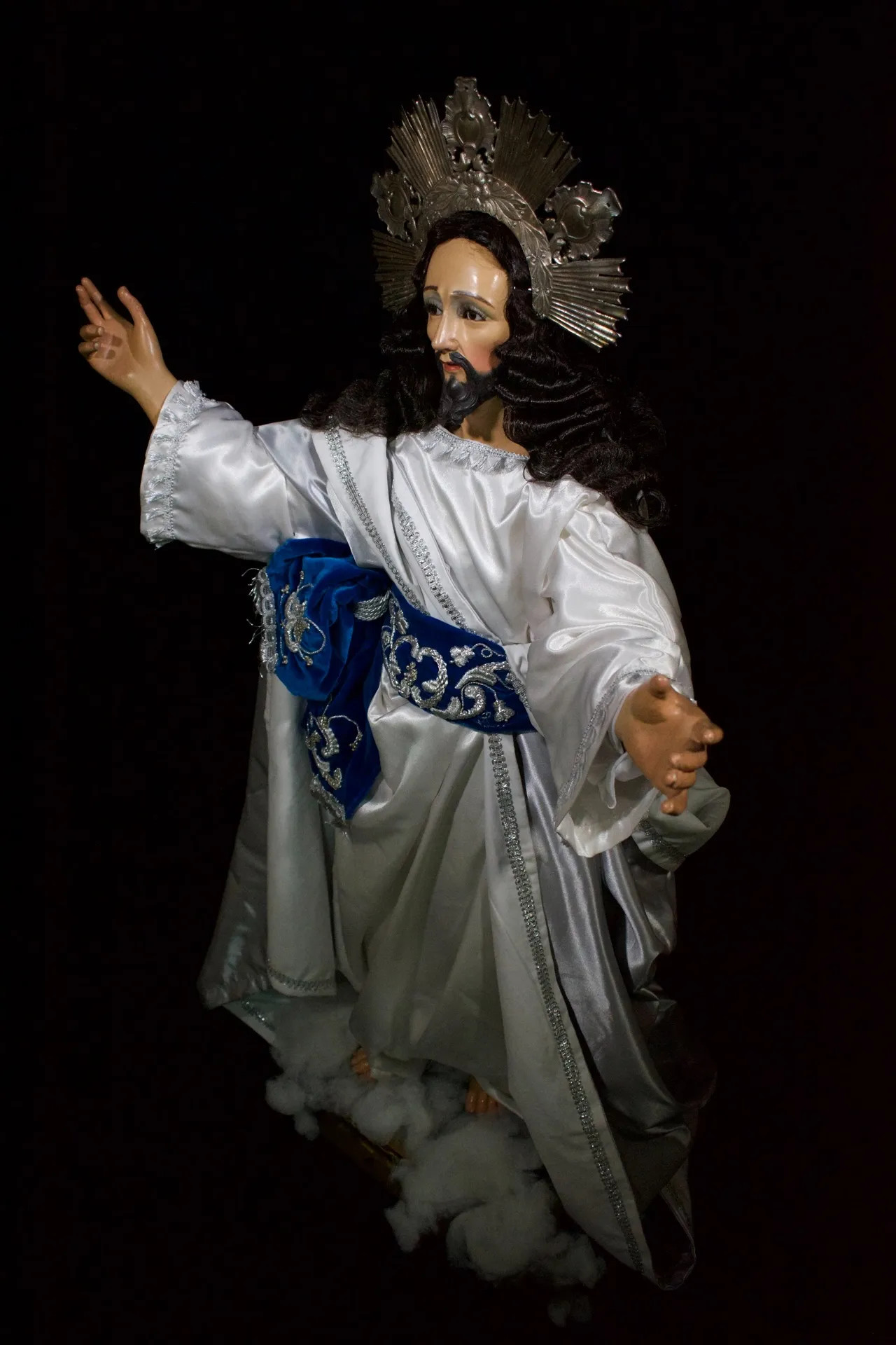Jesús de la Transfiguración visto en tres cuartos, con los brazos abiertos, de pie sobre nubes de algodón