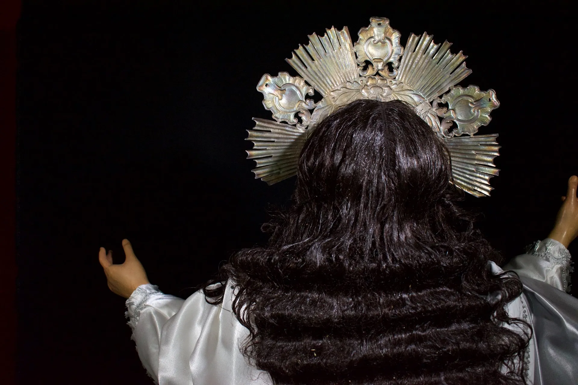 Resplandor de plata de Jesús de la Transfiguración visto por detrás, sobre la cabellera oscura