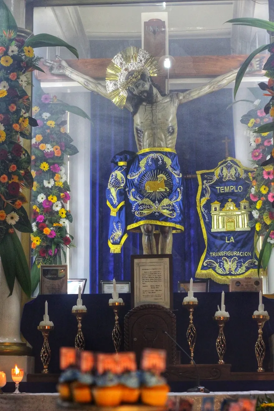 Imagen monumental del Cristo Crucificado (Divino Salvador del Mundo) en el altar mayor con faldellín azul bordado en oro