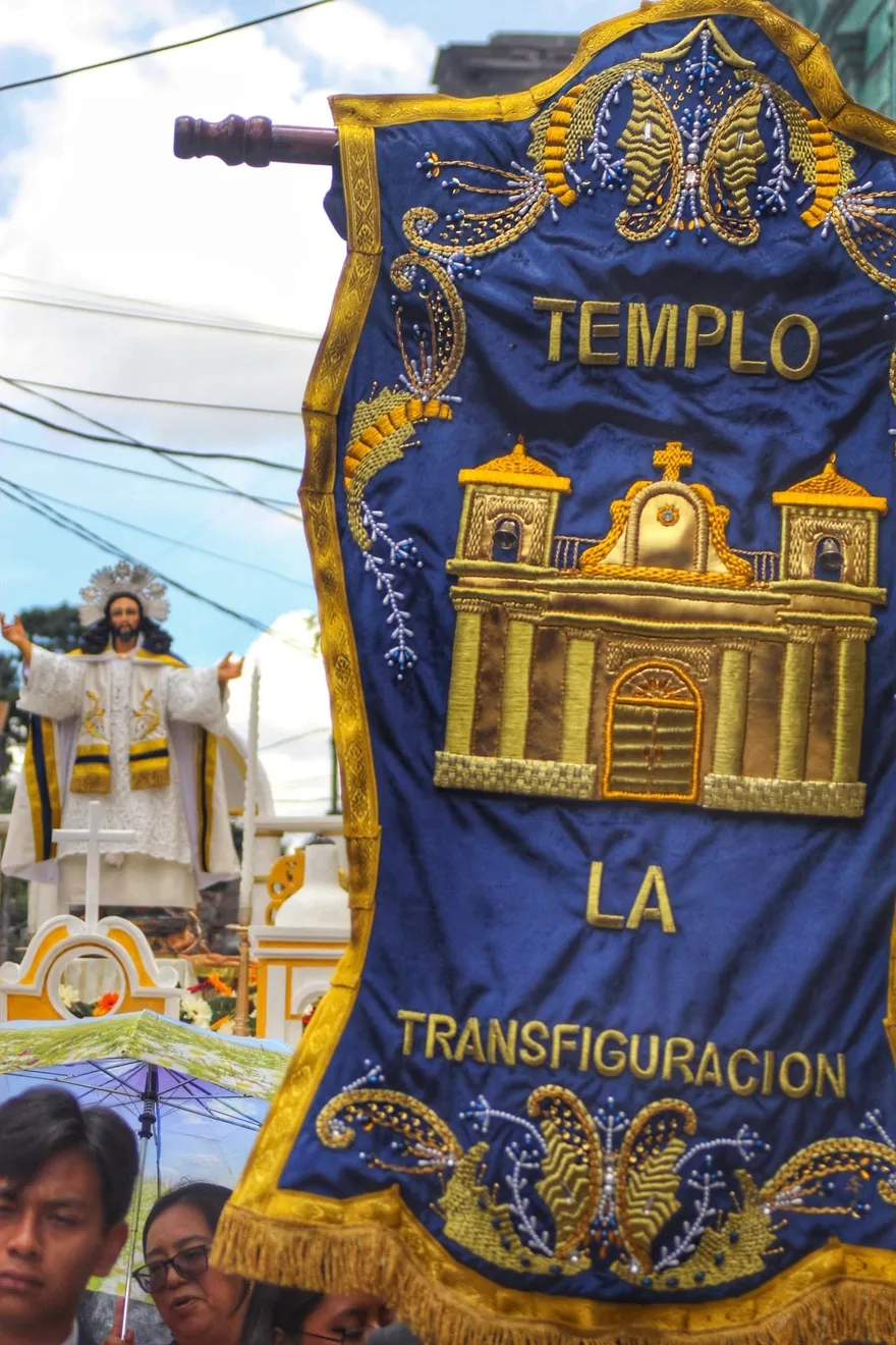 Estandarte bordado en hilo de oro del Templo La Transfiguración precediendo a la imagen de Jesús de la Transfiguración