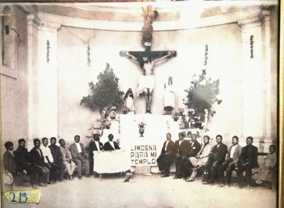Fotografía histórica del altar mayor con la imagen del Cristo Crucificado (Salvador del Mundo) y devotos del templo